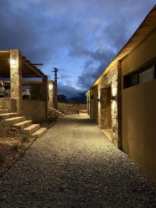 an empty alleyway between two buildings with a cloudy sky at Distinguida Cabaña en Purmamarca in Purmamarca
