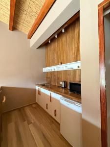 a kitchen with white cabinets and a wooden floor at Distinguida Cabaña en Purmamarca in Purmamarca