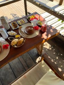 a wooden table with food and drinks on it at Pousada Nascente do Sol in Ilha de Boipeba