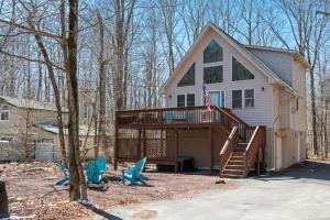 a house with a deck and some blue chairs at Hot Tub Fire-place Game Room Arrowhead Lake in Thornhurst