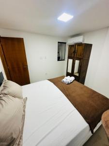a bedroom with a large white bed in a room at Apto 2 quartos perto da praia in Rio de Janeiro