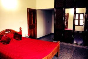 a bedroom with a red bed with a wooden frame at Aneys River View Home stay & Resort in Palakkad
