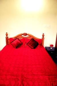 a red bed with red sheets and pillows at Aneys River View Home stay & Resort in Palakkad