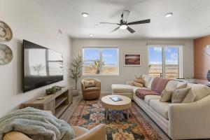 een woonkamer met een bank en een plafondventilator bij Chasing Sunsets condo in St. George