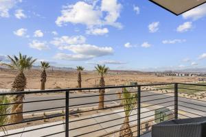 een balkon met palmbomen op het strand bij Chasing Sunsets condo in St. George