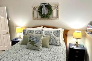 a bedroom with a bed with pillows and two lamps at Harbor Point Haven in New Shoreham