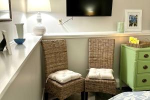 two wicker chairs sitting under a counter in a bedroom at Harbor Point Haven in New Shoreham