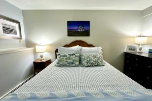 a small bedroom with a bed with two lamps at Harbor Point Haven in New Shoreham