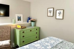 a bedroom with a green dresser and a bed at Harbor Point Haven in New Shoreham