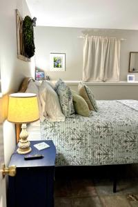 a bedroom with a bed and a table with a lamp at Harbor Point Haven in New Shoreham +12 photos