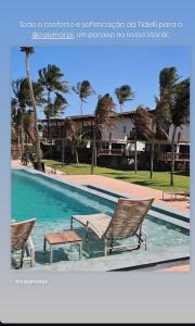 einen Pool mit 2 Stühlen und Palmen in der Unterkunft Chalé Leão Marinho Cajueiro da Praia in Cajueiro