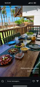 einen Tisch mit Teller mit Speisen darüber in der Unterkunft Chalé Leão Marinho Cajueiro da Praia in Cajueiro