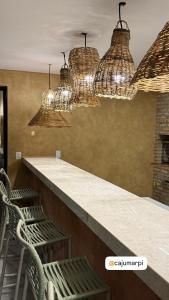 eine Bar mit zwei Stühlen und Kronleuchtern in der Unterkunft Chalé Leão Marinho Cajueiro da Praia in Cajueiro