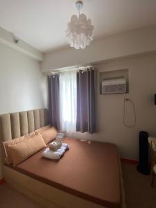 a bedroom with a large bed with a chandelier at A&A cabin in Manila
