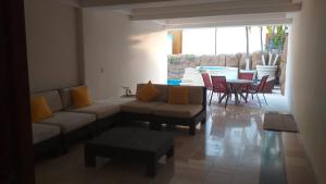 a living room with a couch and a table and chairs at Marbella 25 in Acapulco