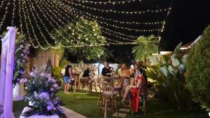 a group of people sitting in chairs in a garden with lights at Bali Dyana Villas in Seminyak +151 photos