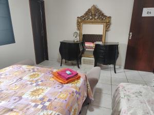 a dressing room with a table and a mirror at Suite tripla Pousada Canto dos Pássaros in Cianorte