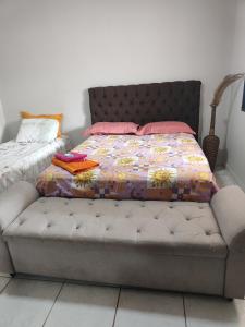 - un lit avec des oreillers roses dans une chambre dans l'établissement Suite tripla Pousada Canto dos Pássaros, à Cianorte 1 autre photo