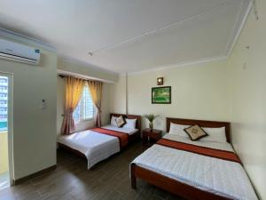 a bedroom with two beds and a window at Hoa Lư Hotel in Sầm Sơn +9 photos