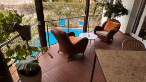 a balcony with chairs and a table and a pool at Le Pavillon Wengué in Dakar