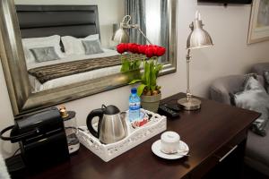 a room with a table with a bed and a mirror at Barney Barnato in Kimberley