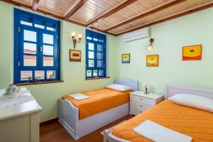 two beds in a room with two windows at Chalki Jewel in Halki