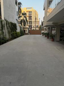 an empty parking lot with palm trees and buildings at Poonam apartments 2 in Prayagraj