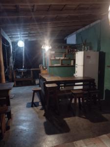 una sala da pranzo con tavolo in legno e frigorifero di Hostel Mata House Nova Caraíva a Porto Seguro