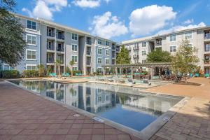 a courtyard with a pool in front of a building at Stunning 1bd Apartment I Frisco near Dallas I Pool, Gym, Work Space in Frisco
