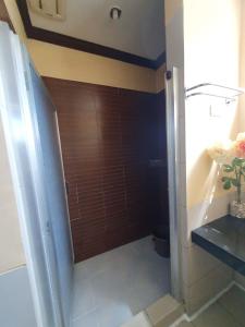 a bathroom with a shower with a wooden wall at Burnham Unit 504 Baguio Condo Transient by Dei Gratia in Baguio