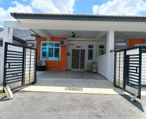 a house with an orange door and a gate at Zaffienadh Homestay Bahau in Bahau