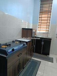 a kitchen with a stove and a counter top at Zaffienadh Homestay Bahau in Bahau +9 photos