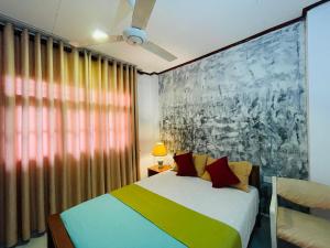 a bedroom with a bed and a large window at Zen Zone in Weligama