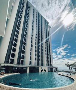 a large building with a swimming pool in front of it at The Shore by New Voyage in Kota Kinabalu