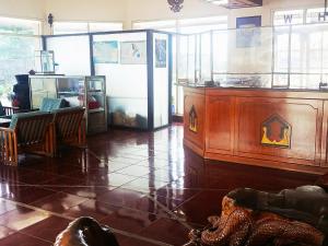 a room with a counter with a refrigerator and a table at Hotel Wijaya Purwokerto in Purwokerto