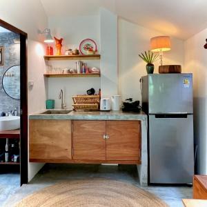 a kitchen with a stainless steel refrigerator and a sink at PaChaSi Samui Bungalows in Ban Bang Po
