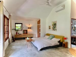 a bedroom with a bed and a table in it at PaChaSi Samui Bungalows in Ban Bang Po