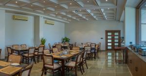 a restaurant with wooden tables and chairs in a room at Ishwar Kot in Sheoganj