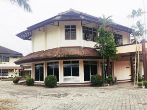 a large white building with plants in front of it at Hotel Wijaya Purwokerto in Purwokerto