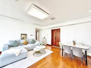 un soggiorno con un divano e un tavolo di Shanghai downtown Tyms B&B Near Hongqiao Metro and Jiaotong University High view 3bedroom&2bathroom a Shanghai