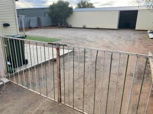 a metal fence in front of a garage at Miners' cottage in Broken Hill