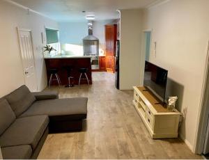 a living room with a couch and a flat screen tv at Miners' cottage in Broken Hill
