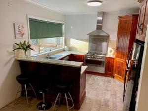 a kitchen with a sink and a stove top oven at Miners' cottage in Broken Hill