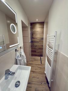 a bathroom with a white sink and a wooden door at Historisches Wohnen nahe Rathaus und Steintor in Malchin