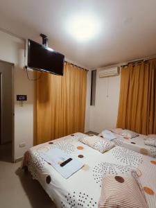カリにあるHotel casa gustadoraの薄型テレビ付きの部屋にベッドが2つあります
