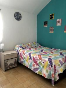 a bedroom with a bed and a clock on the wall at Casa Grace Apto con vista al mar in Cartagena de Indias