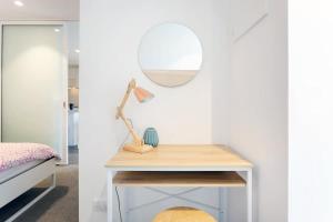 a bedroom with a bed and a table with a mirror at Le Oasis Apt inCBD 2BR 3Beds near Southern cross in Melbourne