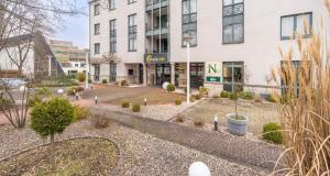 a building with a garden in front of it at PLAZA INN Braunschweig City Süd in Braunschweig +61 photos