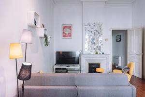 Una sala de estar con un sofá y un televisor. en Demeure & Confort by Les Demeures de Rachel, en Nimes