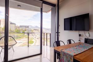 une salle à manger avec une table et une grande fenêtre dans l'établissement Gray Fox Apartments - Bahía, à Ushuaia